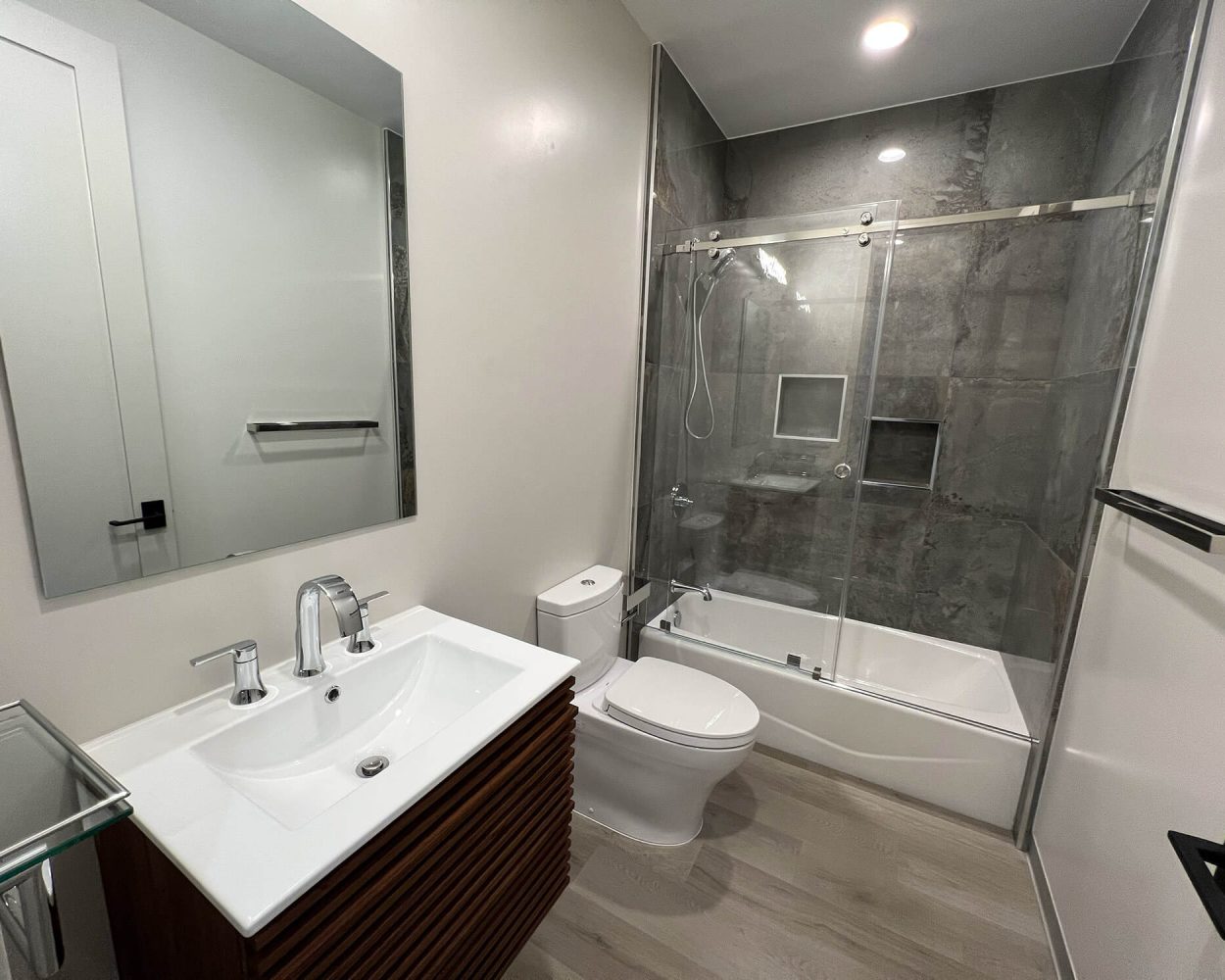 Remodeled bathroom in SF Bay Area with clear frameless sliding shower door on bathtub shower