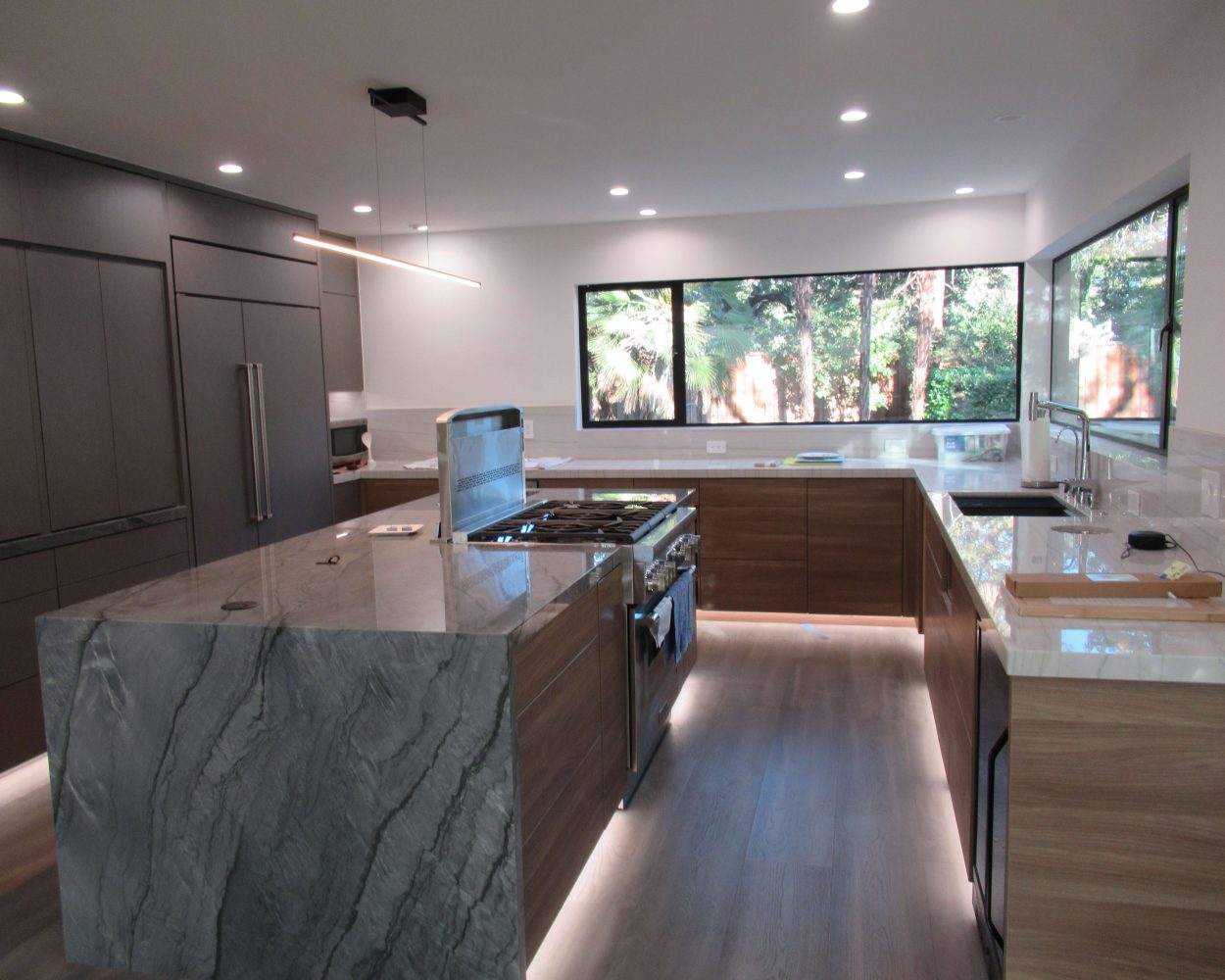 Remodeled kitchen by Bay Area Design and Construction with marble counters and under lit cabinets.